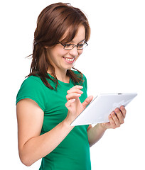 Image showing Young cheerful woman is using tablet