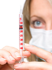 Image showing Young nurse is preparing syringe for injection