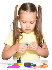 Image showing Little girl is playing with plasticine