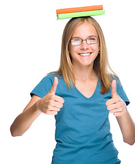 Image showing Young student girl is showing thumb up gesture