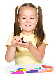 Image showing Little girl is playing with plasticine