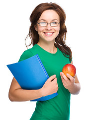 Image showing Young student girl is holding book and apple