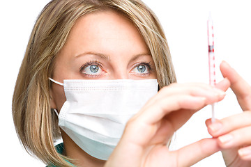 Image showing Young nurse is preparing syringe for injection