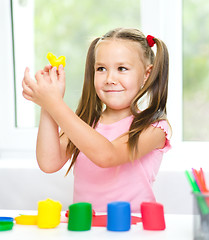 Image showing Little girl is playing with plasticine