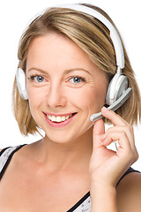 Image showing Lovely young woman is talking to customers