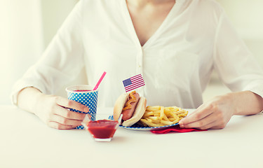 Image showing close up of woman eating hotdog and french fries