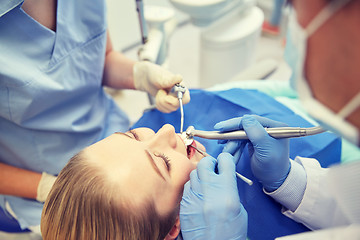 Image showing close up of dentist treating female patient teeth