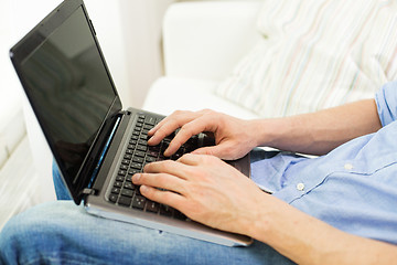 Image showing close up of man typing on laptop computer at home