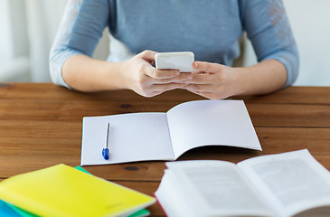 Image showing close up of student with smartphone and notebook