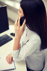 Image showing close up of woman talking on smartphone at office