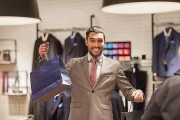 Image showing happy man with shopping bags at clothing store