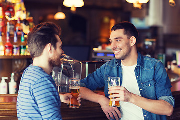 Image showing happy male friends drinking beer at bar or pub