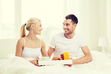 Image showing happy couple having breakfast in bed at home