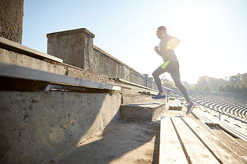 Image showing happy young man running upstairs on stadium