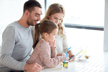 Image showing happy family with tablet pc at restaurant