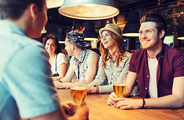 Image showing happy friends drinking beer and talking at bar