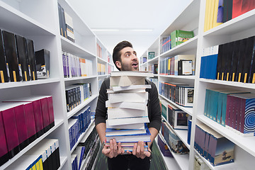 Image showing Student holding lot of books in school library