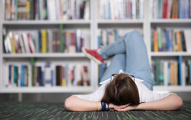 Image showing female student study in library, using tablet and searching for 