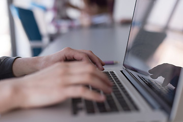 Image showing close up of business womans hand typing on laptop with team on m