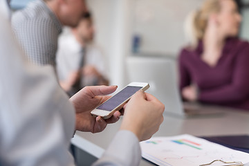 Image showing close up of  busineswoman hands  using smart phone on meeting