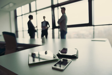 Image showing close up of tablet, business people on meeting in background