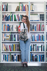 Image showing famale student selecting book to read in library