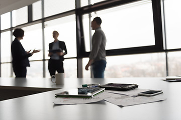 Image showing close up of tablet, business people on meeting in background