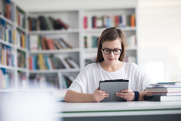 Image showing female student study in school library, using tablet