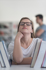 Image showing portrait of famale student selecting book to read in library