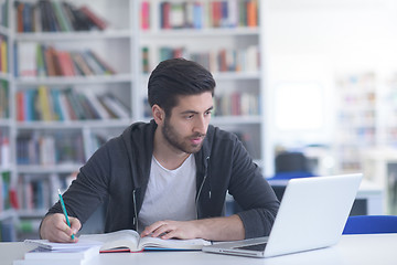 Image showing student in school library using laptop for research