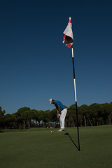 Image showing golf player hitting shot at sunny day