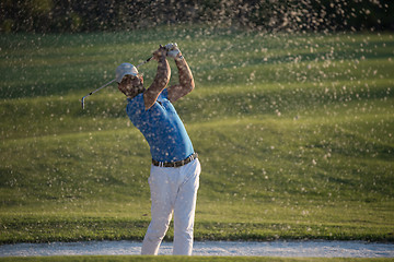 Image showing golfer hitting a sand bunker shot on sunset