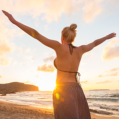 Image showing Free Happy Woman Enjoying Sunset on Sandy Beach