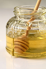 Image showing honey and wooden dipper in a glass