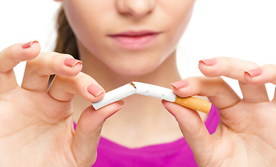 Image showing Young woman is breaking a cigarette