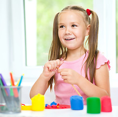 Image showing Girl is having fun while playing with plasticine