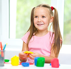 Image showing Little girl is playing with plasticine