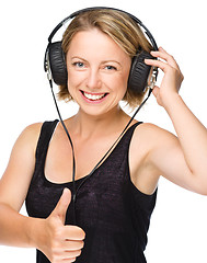 Image showing Young woman enjoying music using headphones