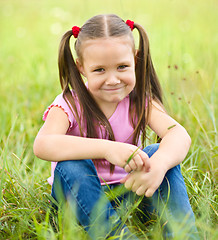 Image showing Portrait of a little girl sitting on green grass