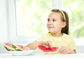 Image showing Cute little girl is eating watermelon