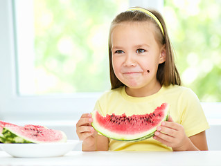 Image showing Cute little girl is eating watermelon