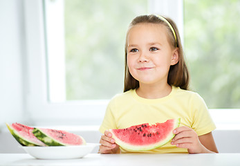 Image showing Cute little girl is eating watermelon