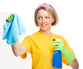 Image showing Young woman is cleaning glass using rag