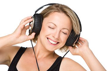 Image showing Young woman enjoying music using headphones