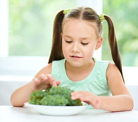 Image showing Cute little girl is eating green grapes