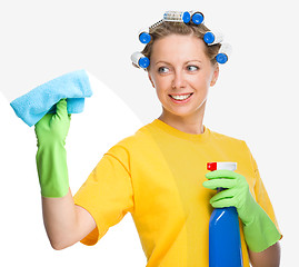 Image showing Young woman is cleaning glass using rag