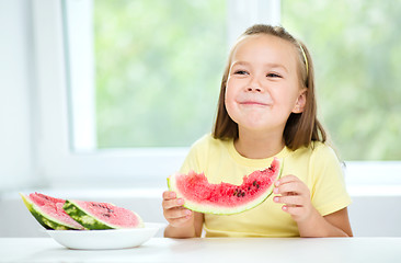 Image showing Cute little girl is eating watermelon