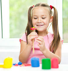 Image showing Little girl is playing with plasticine