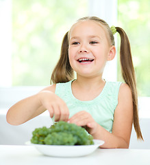 Image showing Cute little girl is eating green grapes