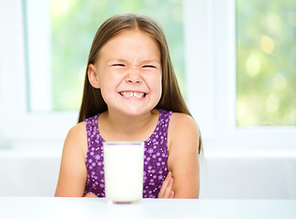 Image showing Sad little girl with a glass of milk